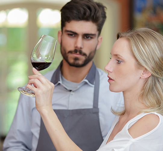Picture of a man and woman examining and tasting wine